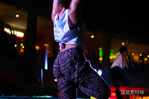 高清摄影 白 tank top 和黑色裤子的女子正在蓝色瑜伽垫上跳跃。