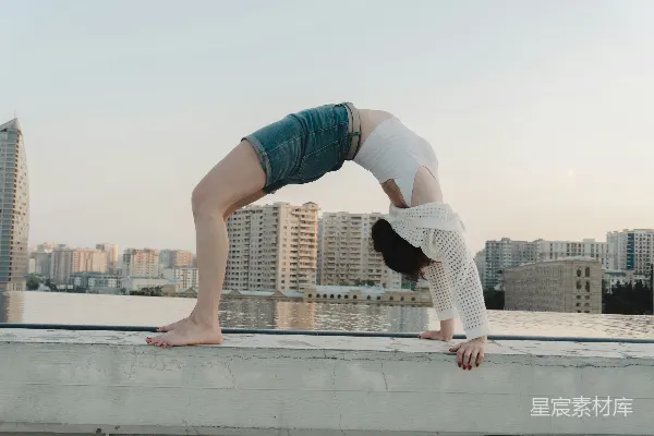 高清摄影 女子在屋顶上做后弯体。