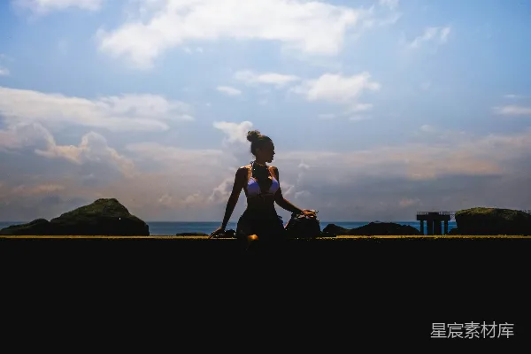 高清摄影 黑色连衣裙上衣和黑色长裤的女人在棕色木制围栏旁坐在日落时分。