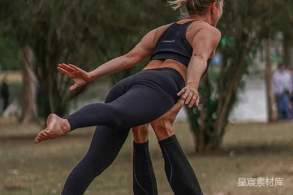 高清摄影 黑色紧身上衣和黑色紧腿裤的女人在白天进行瑜伽练习。