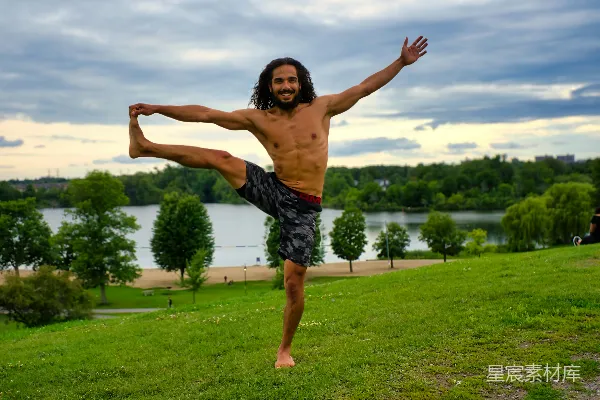 高清摄影 赤膊黑短裤男子白天站在绿色草地上