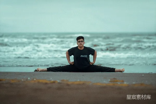 高清摄影 一个男人坐在海滩上的瑜伽姿势中