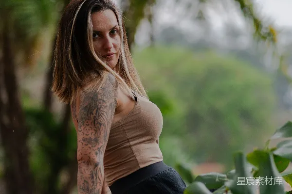 高清摄影 有纹身的女人坐在户外靠近植物的地方