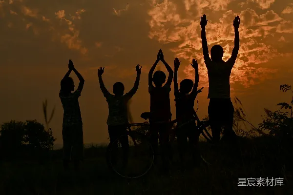 高清摄影 夕阳下人们站立并举起双手的轮廓