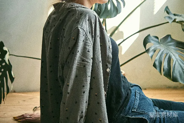 高清摄影 灰T恤女人穿着蓝色牛仔裤坐在棕色木质地板上