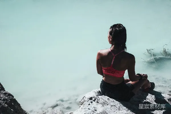 高清摄影 粉色运动bra的女人白天坐在岩石旁的水体附近休憩