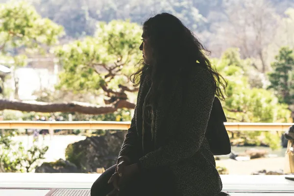 高清摄影 身穿黑白条纹连衣裙的女人坐在棕色木质地板上，白天场景