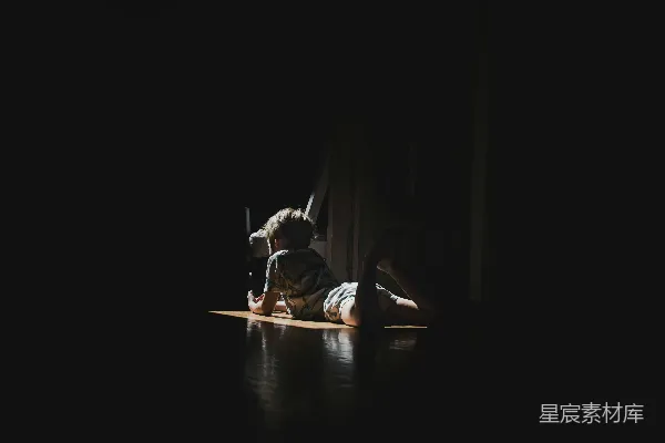 高清摄影 一个人躺在木制地板上，被聚光灯照亮。
