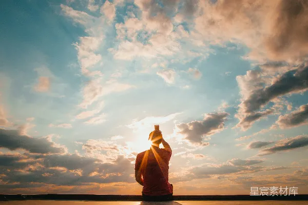 高清摄影 一个人坐在那里背对着蓝天，天空是蓝色和白色的。