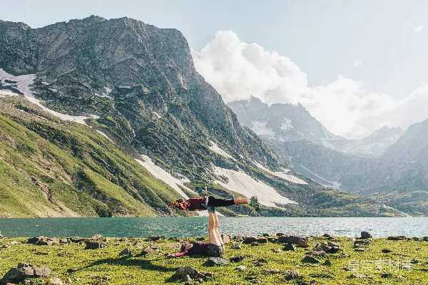 高清摄影 红色夹克的人在湖边的绿色草地上白天站在那里。