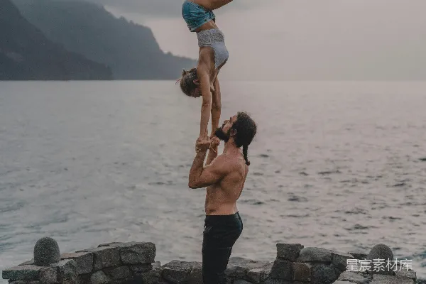 高清摄影 一个男人倒立，背后有一个女人。