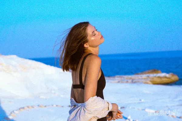 高清摄影 一个女人站在雪中，头发在风中飘动