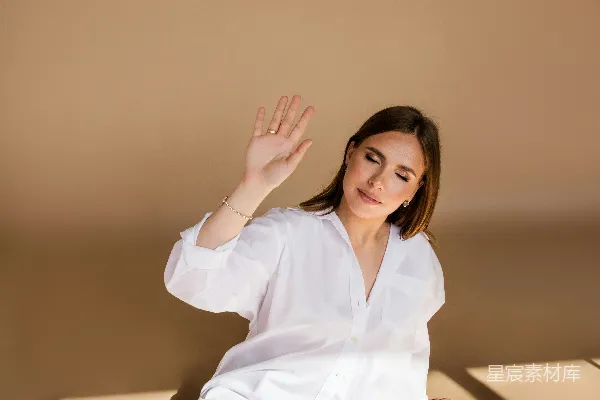 高清摄影 一个女人坐在地上，双手高举在空中