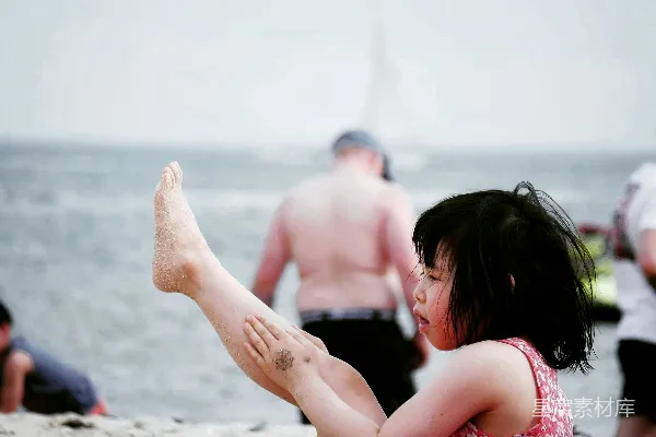 高清摄影 两名女子坐在海滩岸边白天。