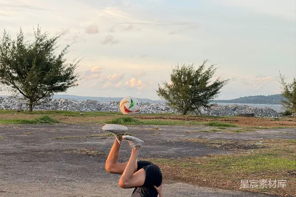 高清摄影 草地上做瑜伽姿势的人，背景是树木。