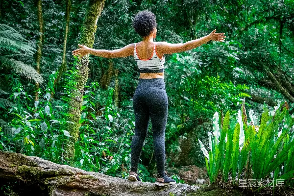 高清摄影 森林中一位女性站在一根木头上