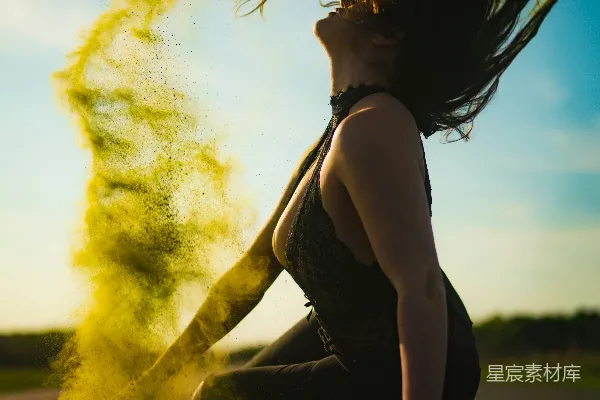 高清摄影 一个女人坐在地上，头发在风中飘动。