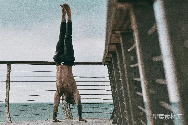 高清摄影 黑色短裤的男人在白天在棕色木制码头上跳跃