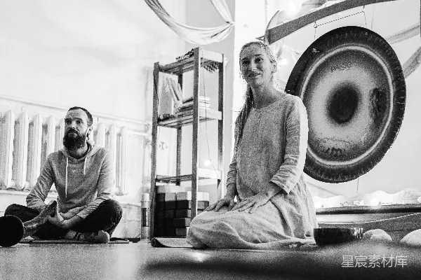 高清摄影 一个男人和一个女人坐在一台洗衣机前面的地面上。