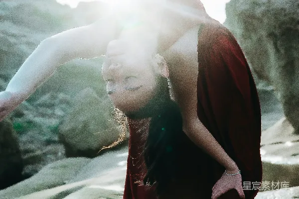 高清摄影 红衣舞者在阳光照耀的岩石海岸上做后空翻。