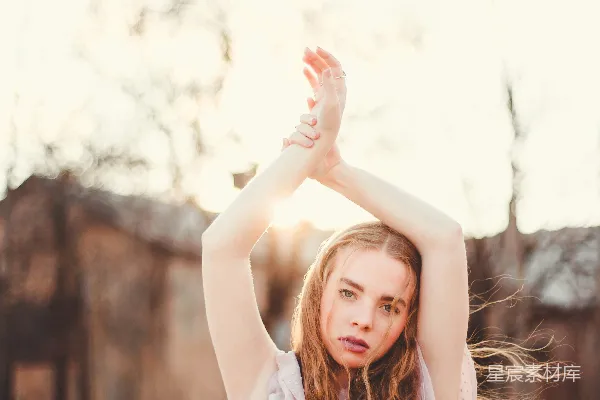 高清摄影 女人双手向上举起站在树木近旁