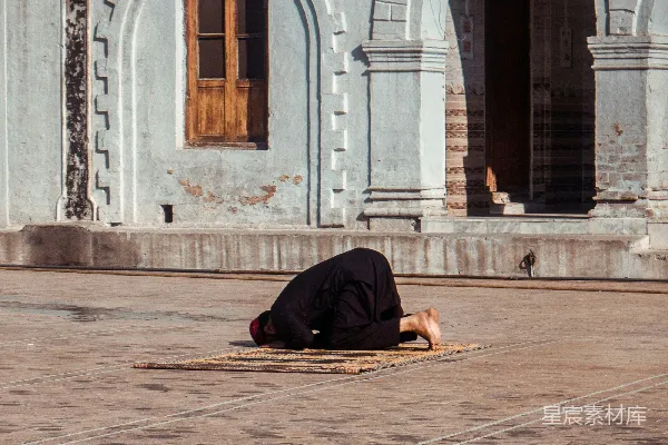 高清摄影 地上趴着一个人，面前是一栋建筑