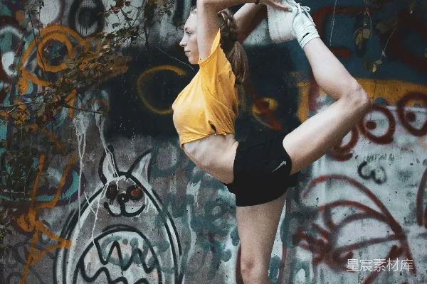 高清摄影 黄色上衣和黑色短裤的女人站在一面涂鸦墙附近