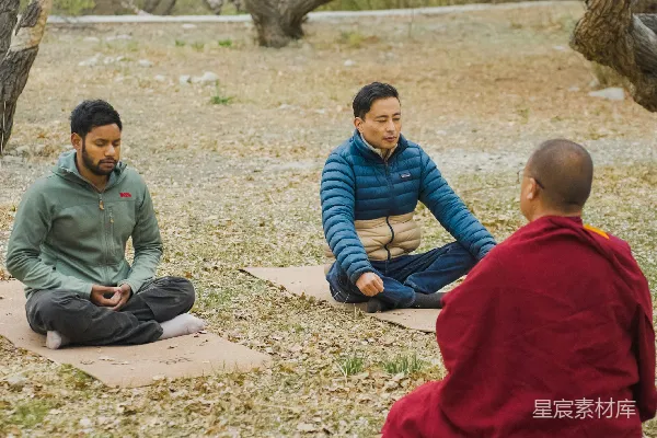 高清摄影 人们在一位佛教僧侣的陪同下在户外进行冥想。