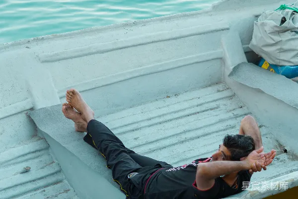 高清摄影 一个男人躺在一艘船上的水里