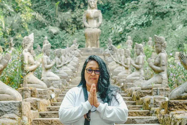 高清摄影 一个女人坐在一排佛像前地上