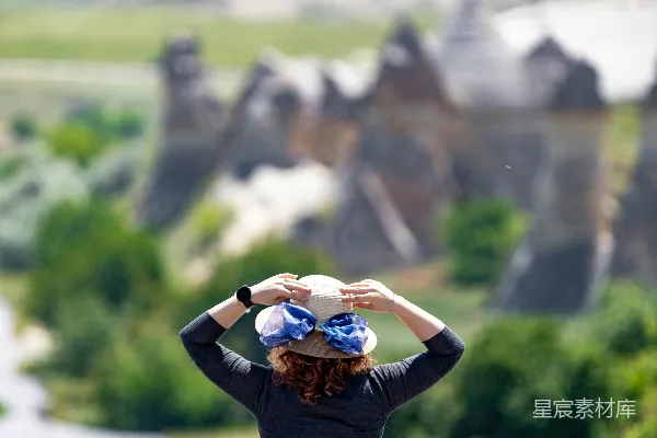 高清摄影 一个女人坐在山上看着一座城堡。