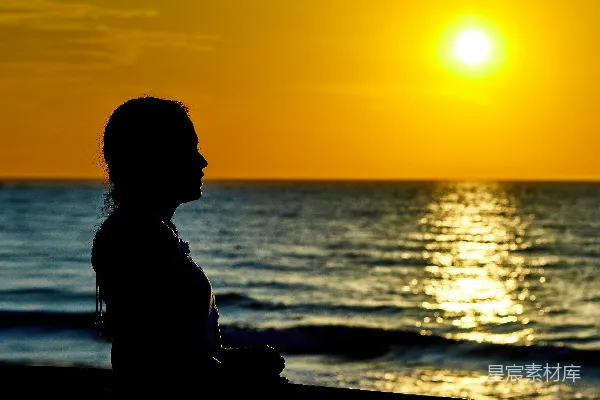 高清摄影 女人站在海滩上，夕阳西下。