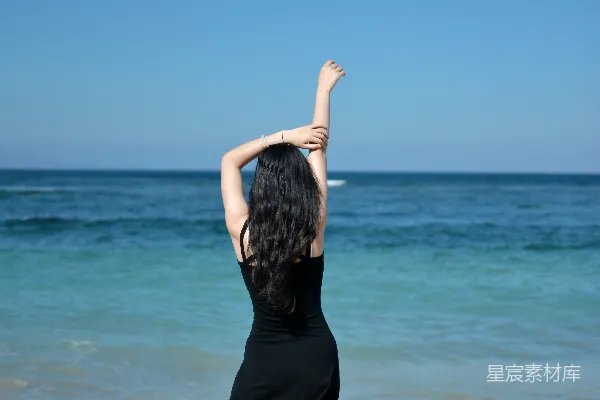 高清摄影 海滩上的女子拥抱阳光。