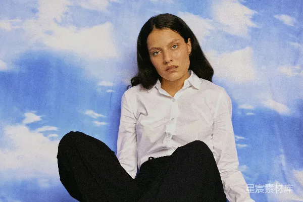 高清摄影 一个女人坐在床上，双腿交叉。