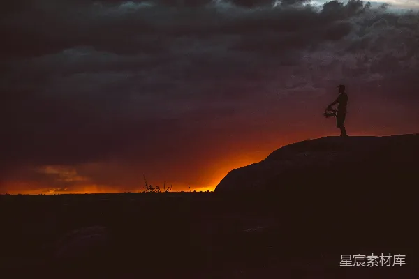高清摄影 夕阳下站立在岩石上的身影