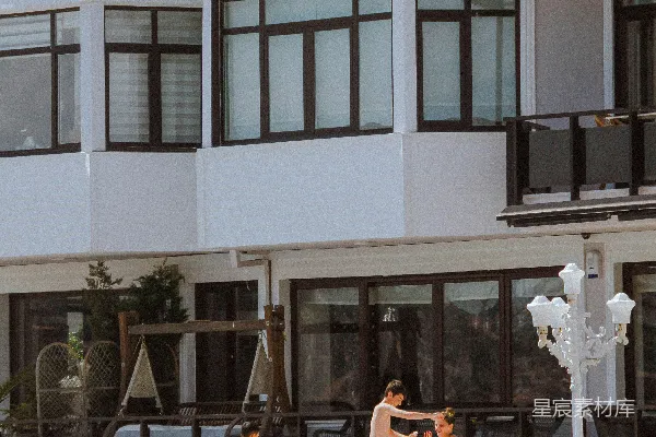 高清摄影 白天人们坐在近处的白色混凝土建筑附近的椅子上