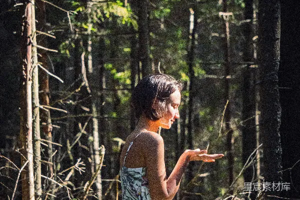 高清摄影 蓝色和白色花卉图案吊领连衣裙的女子在白天的森林中站立。