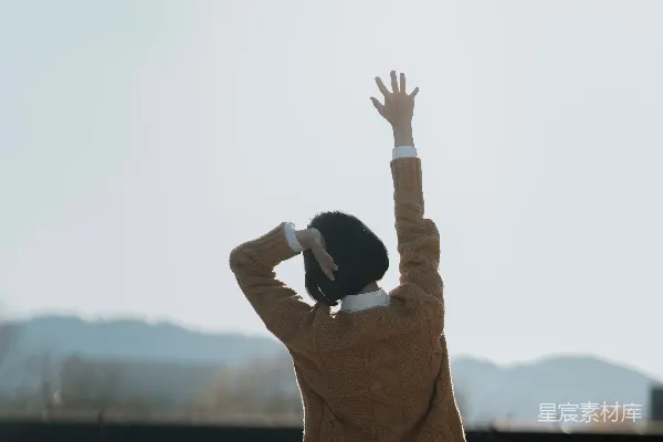 高清摄影 穿着棕色夹克的女人在白天右手举起