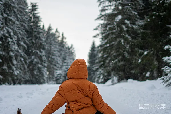 高清摄影 身穿橙色夹克的人在覆盖着积雪的地面上白天坐着