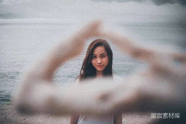 高清摄影 白上衣女子站在海滩上，白天站立。