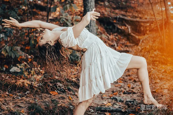 高清摄影 一位白裙子的女人站在森林里的木头上