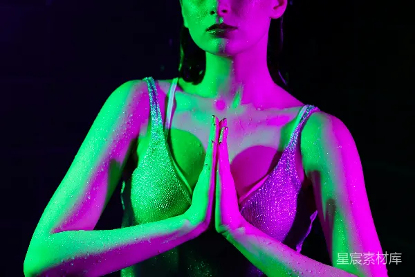 高清摄影 身穿霓虹灯的女子双手交握坐着。