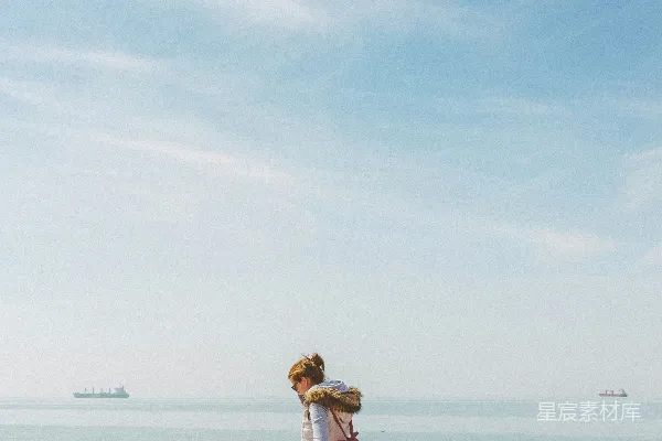 高清摄影 白裙女子站在海滩上，白天