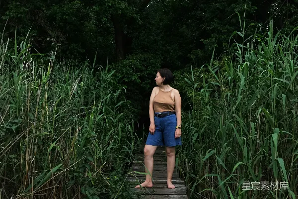 高清摄影 蓝t恤和蓝色直裙的女子站在木制桥上
