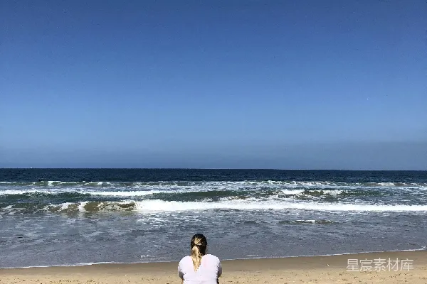 高清摄影 白上衣长袖女子坐在海边白天傍晚时分静坐