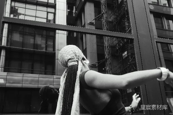高清摄影 脖子上围着围巾的女人站在一栋建筑前