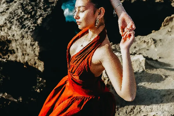 高清摄影 红衣女子站在海边岩石上摆姿势。
