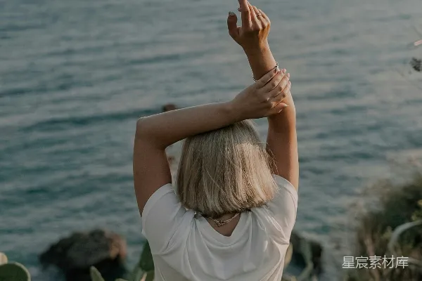 高清摄影 一个女人站在悬崖上俯瞰着海洋。