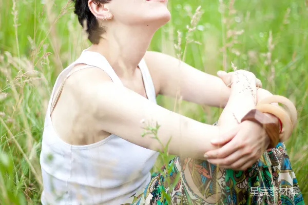 高清摄影 一个女人坐在一丛高高的草中。