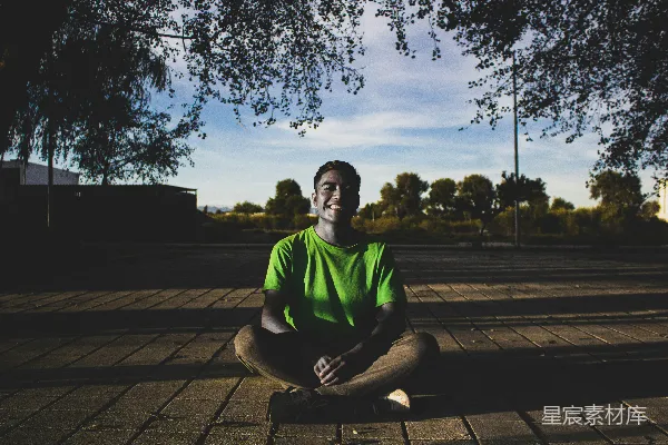高清摄影 一个穿绿色上衣的人坐在木制地板上